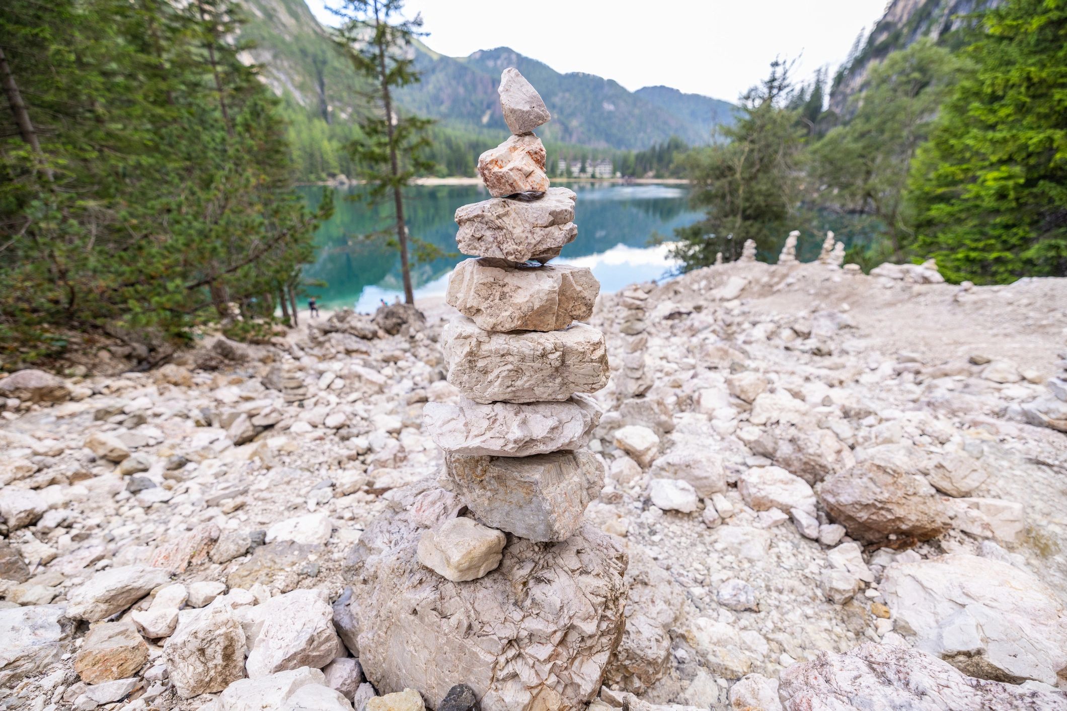 Balanced stones beside a calm alpine lake
