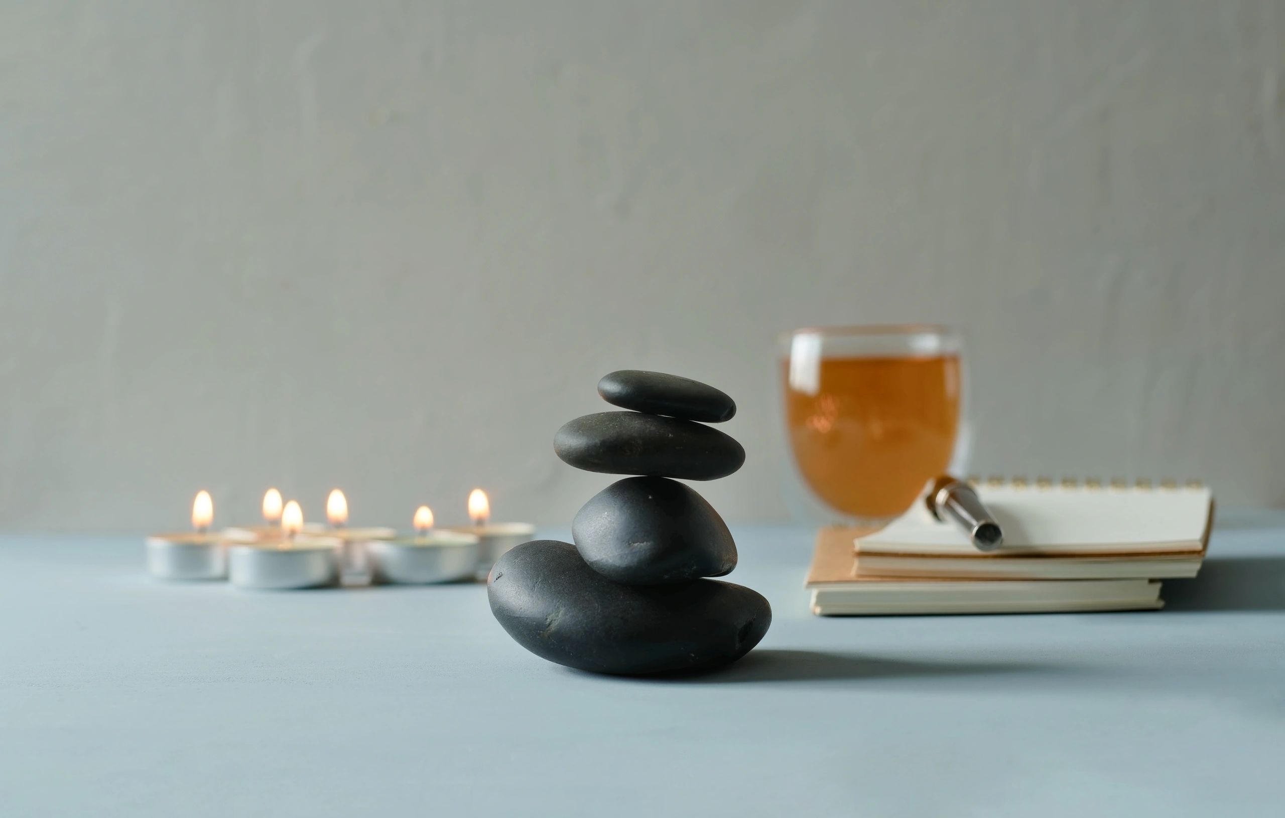 Meditation stones and candles arranged for a calming wellness ritual